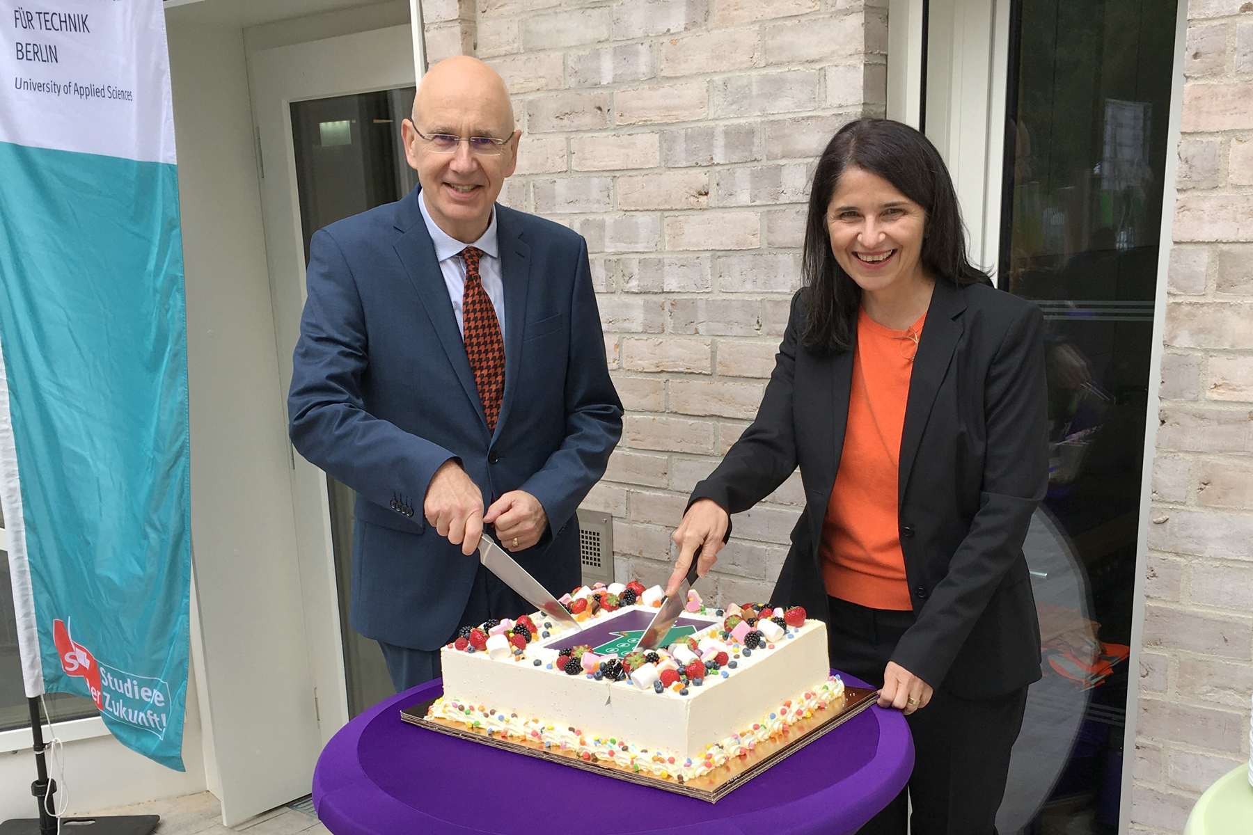 Beuth-Präsident Werner Ullmann und Petra Mai-Hartung, Geschäftsführerin des Studierendenwerks, schneiden eine Torte an
