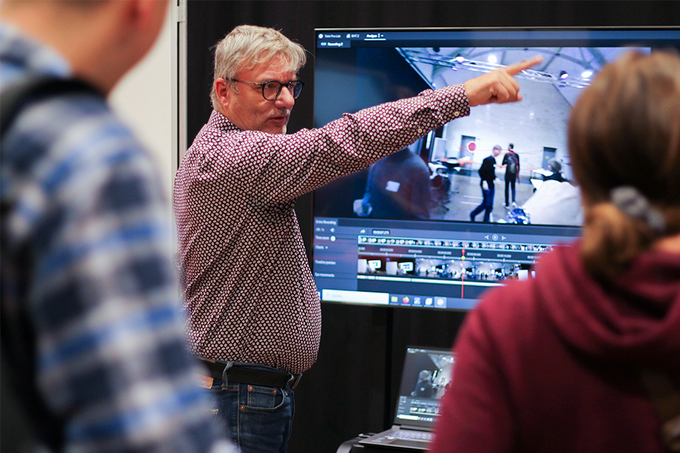 Dr. Frank Merkle vom Deutschen Herzzentrum Berlin steht vor einem Display, auf dem eine VR-Anwendung zu sehen ist und hält einen Vortrag.