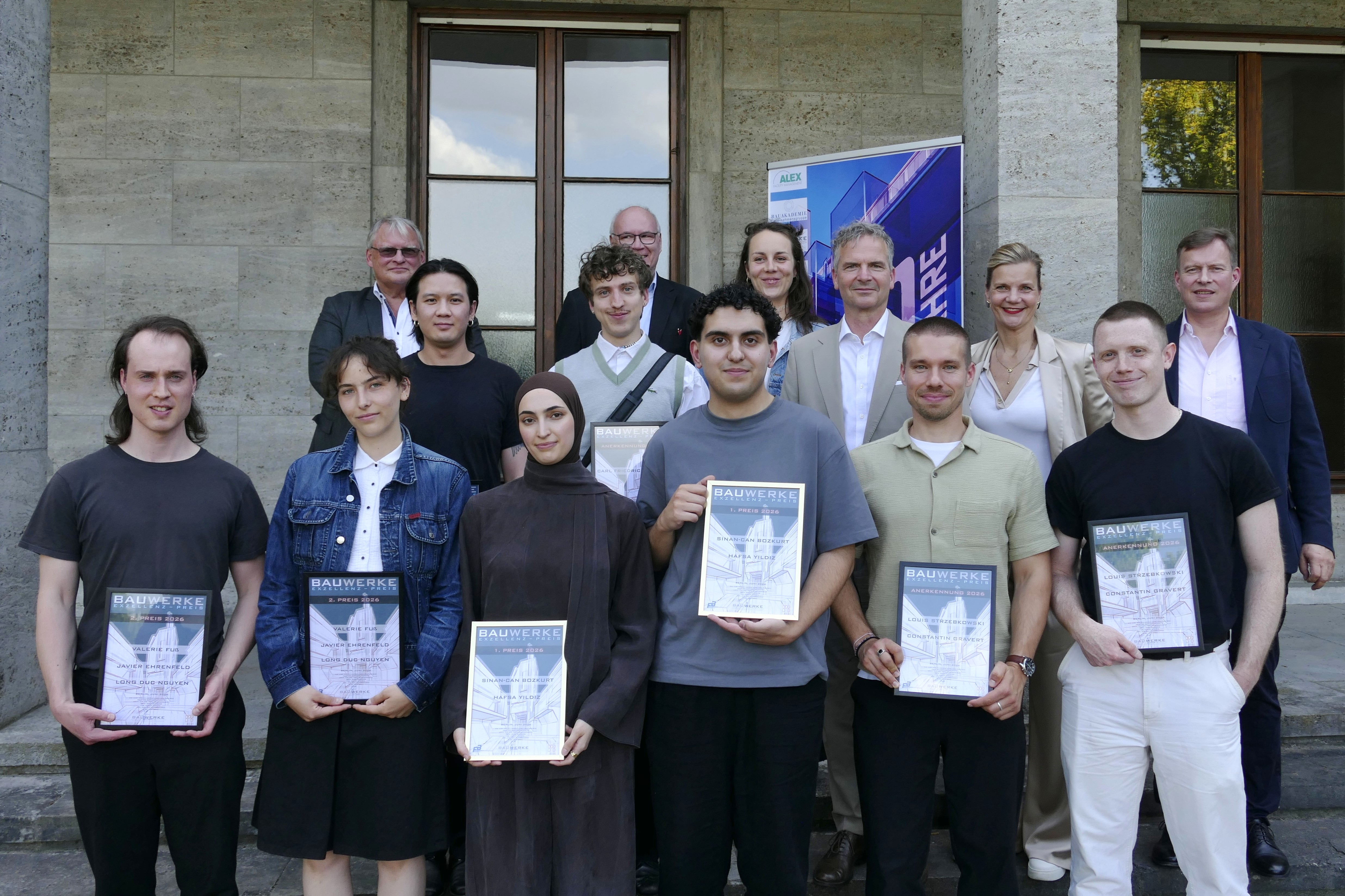 Gruppenbild, die Personen in der vorderen Reihe halten gerahmte Urkunden in den Händen