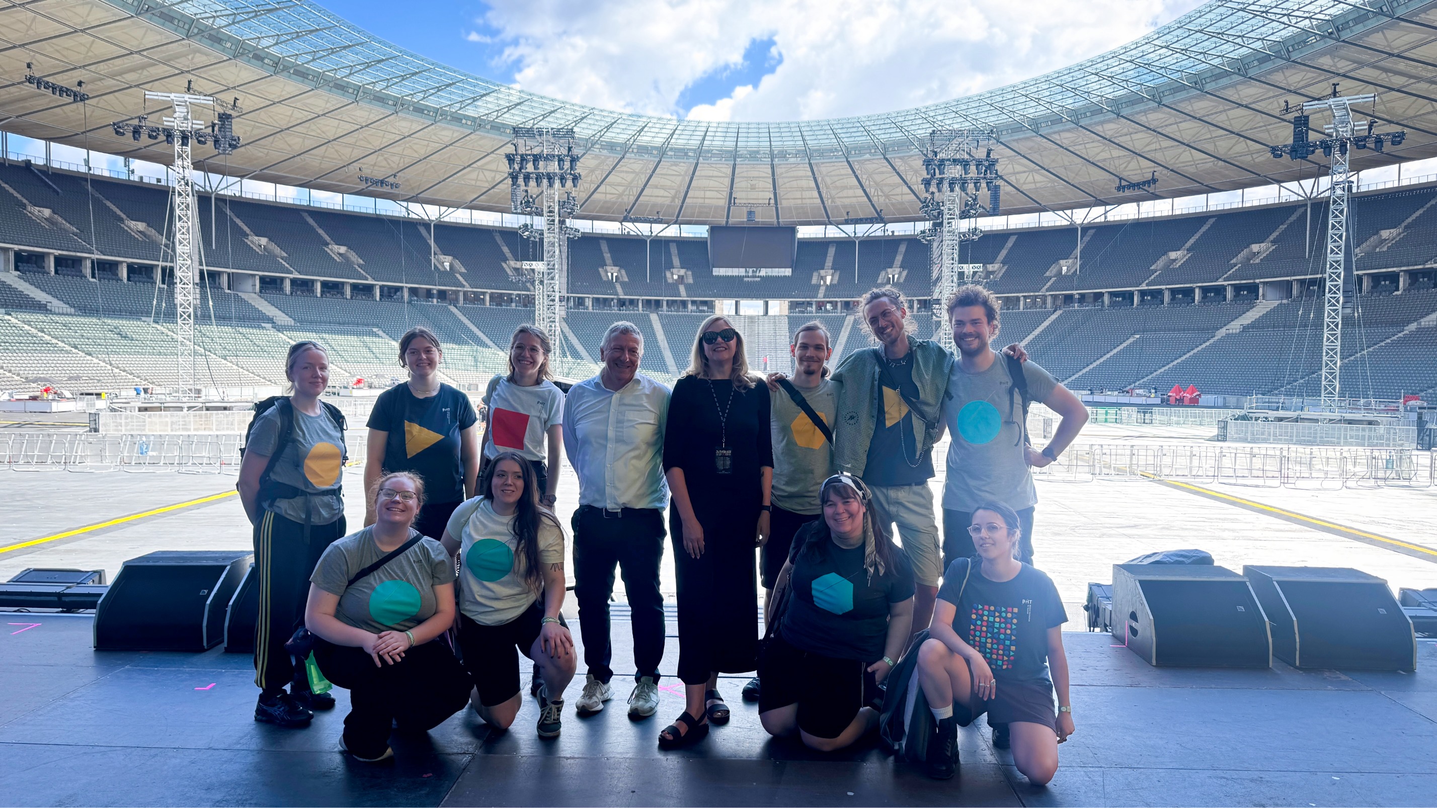 Gruppenfoto von 12 Personen auf der Bühne des Berliner Olympiastadions