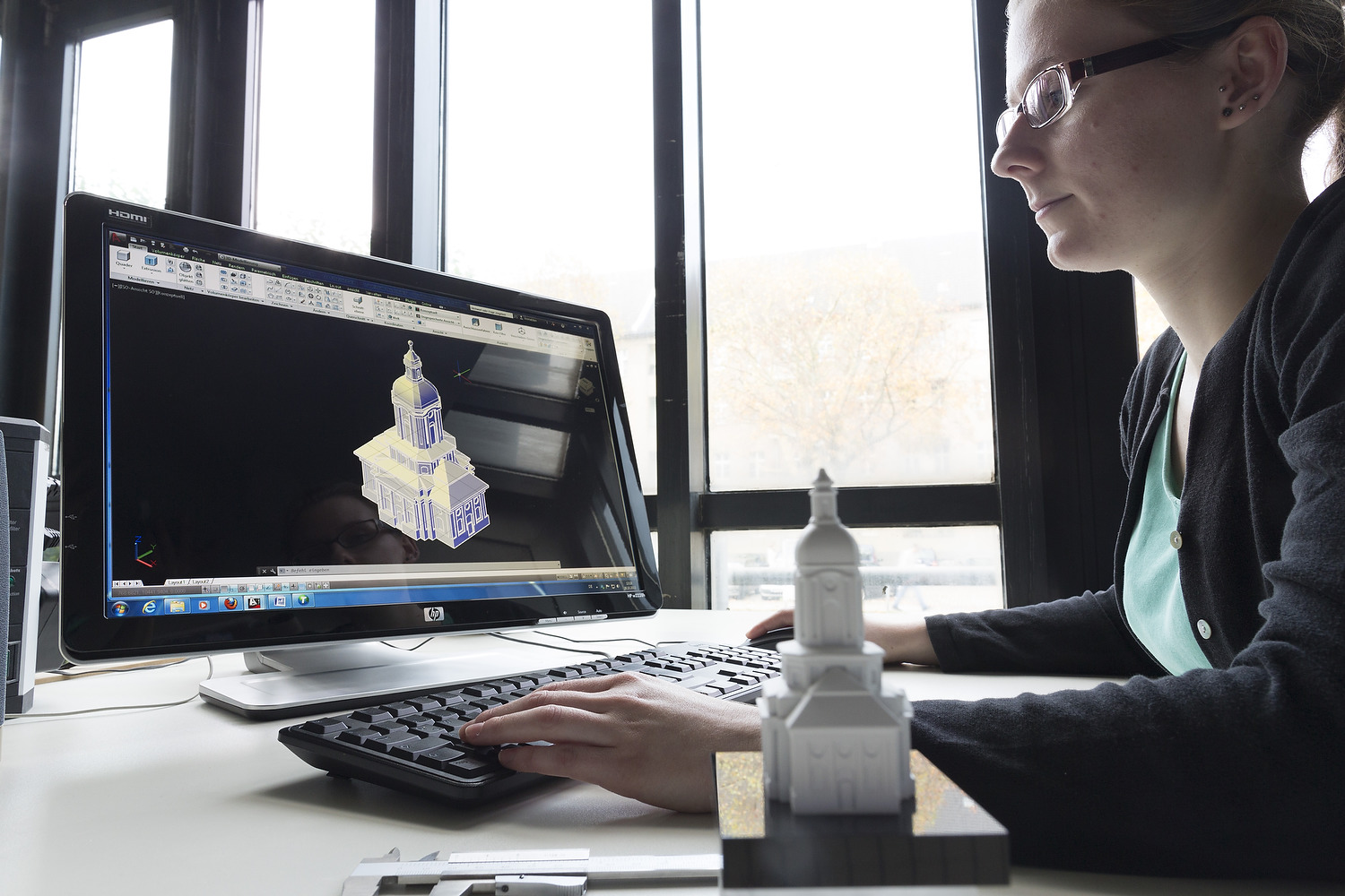 Eine Studentin und eine Miniatur-Gebäudemodell