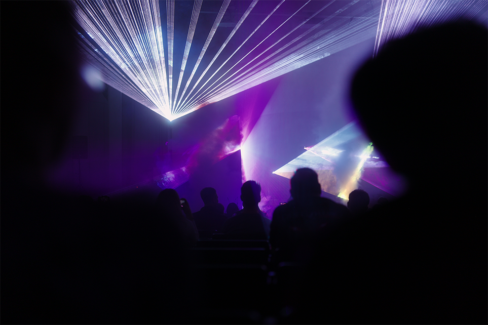 Eine Menschenmenge schaut sich eine Lasershow an.