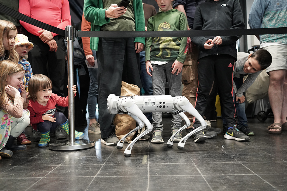 Roboterhund Go1 läuft auf lachende Kinder zu