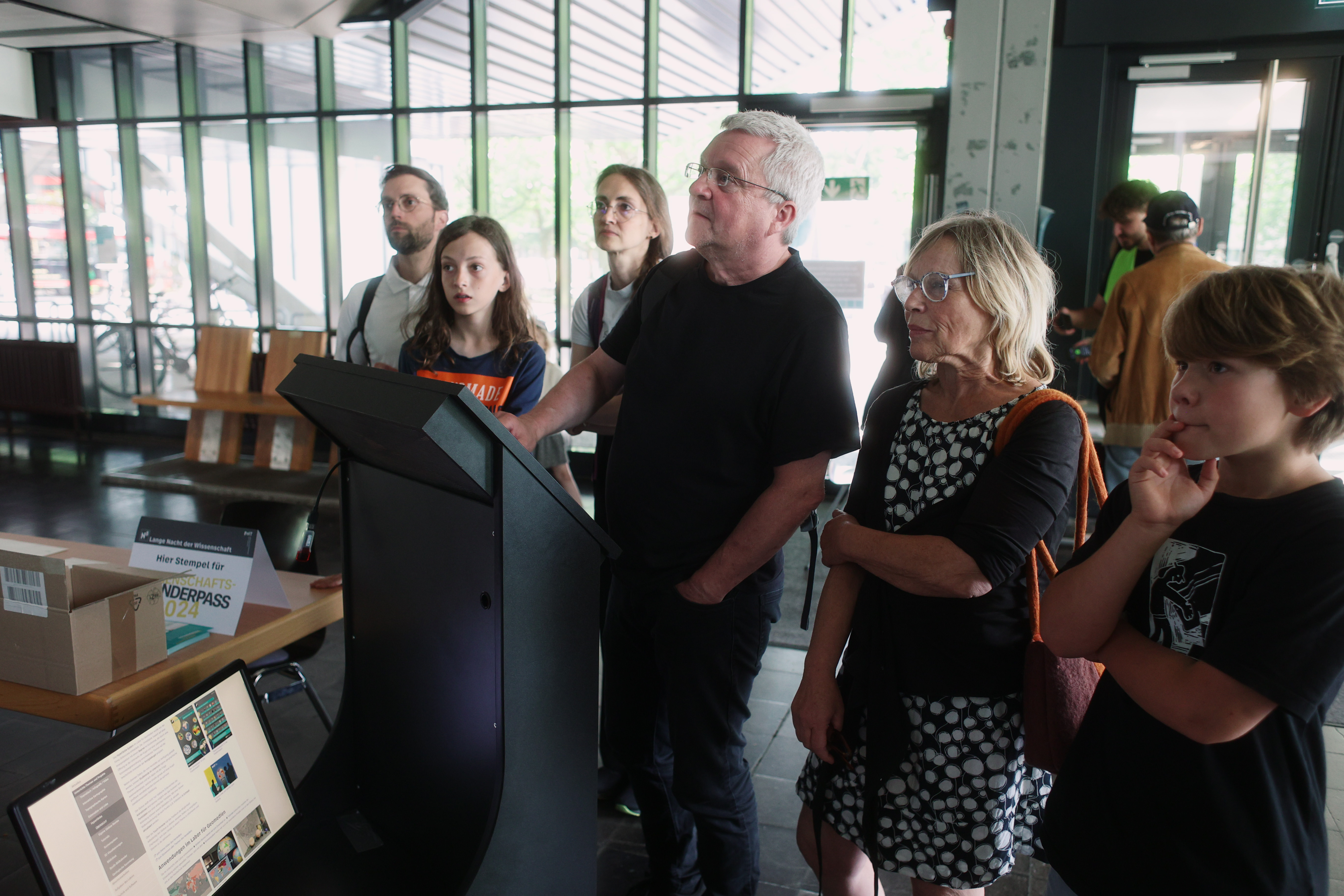 Mehrere Personen betrachten gespannt einen Ausstellungsgegenstand