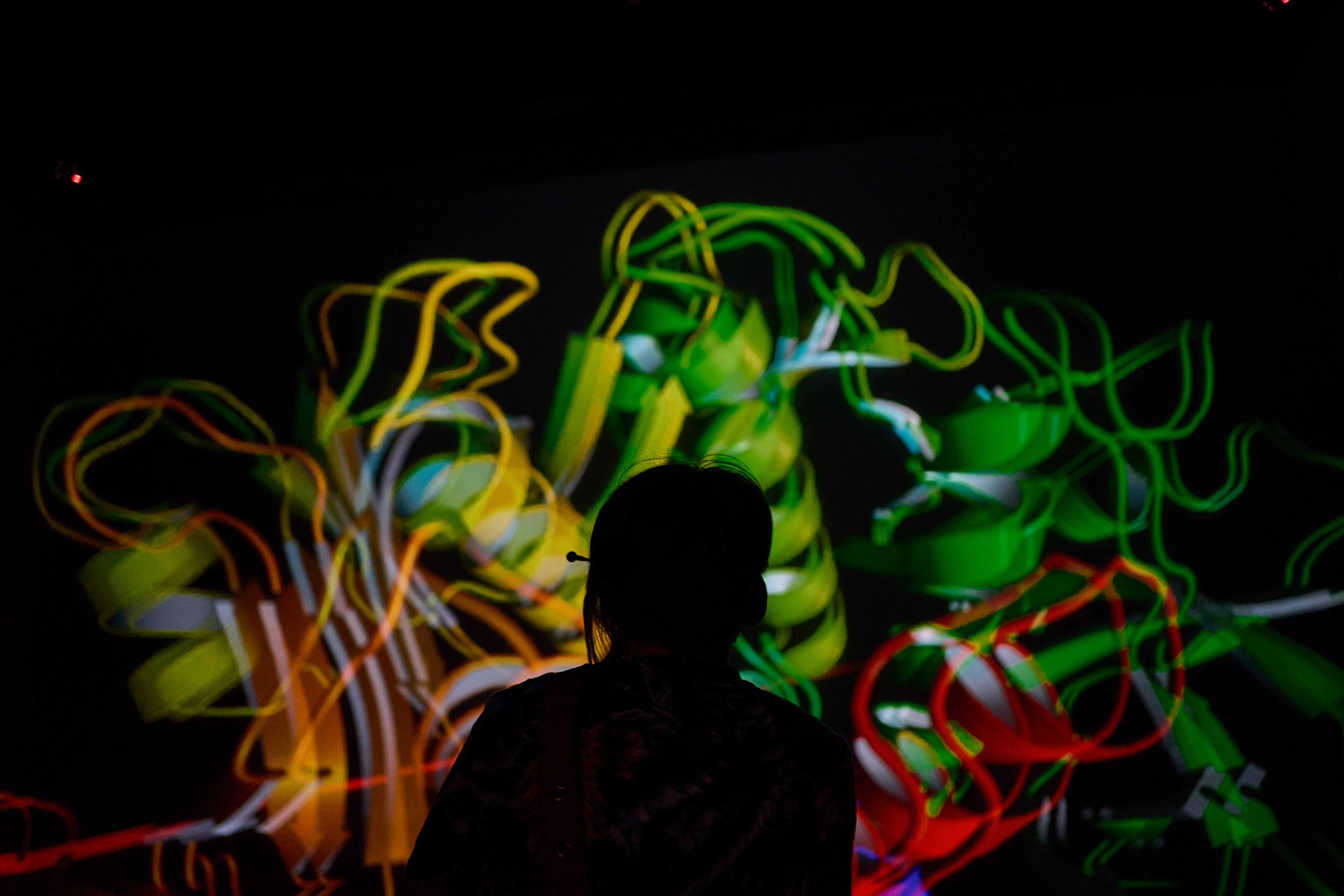 Silhouette vor einer bunten Projektion