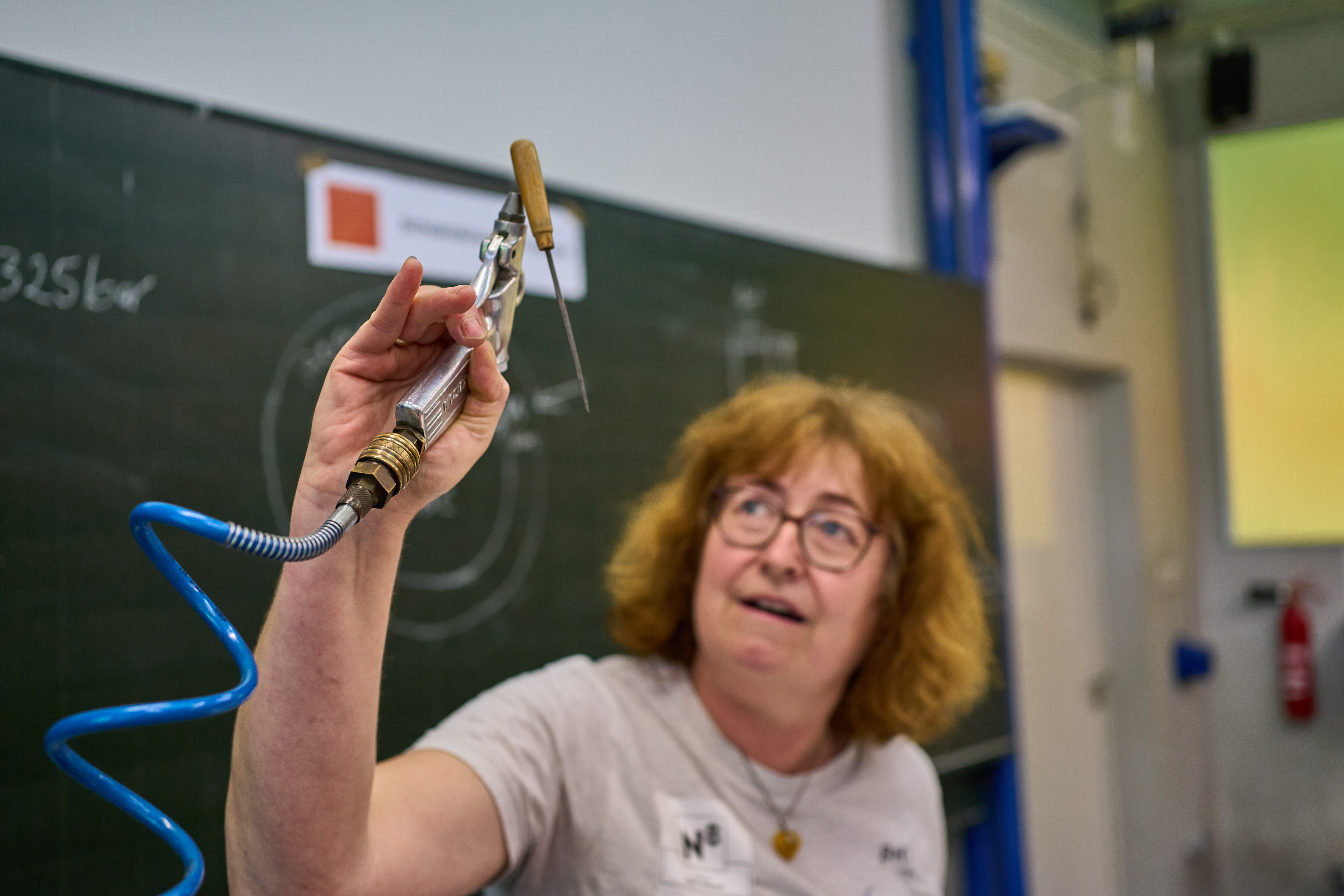 Eine Frau hält einen Gegenstand durch eine Luftdruckpistole in der Schwebe