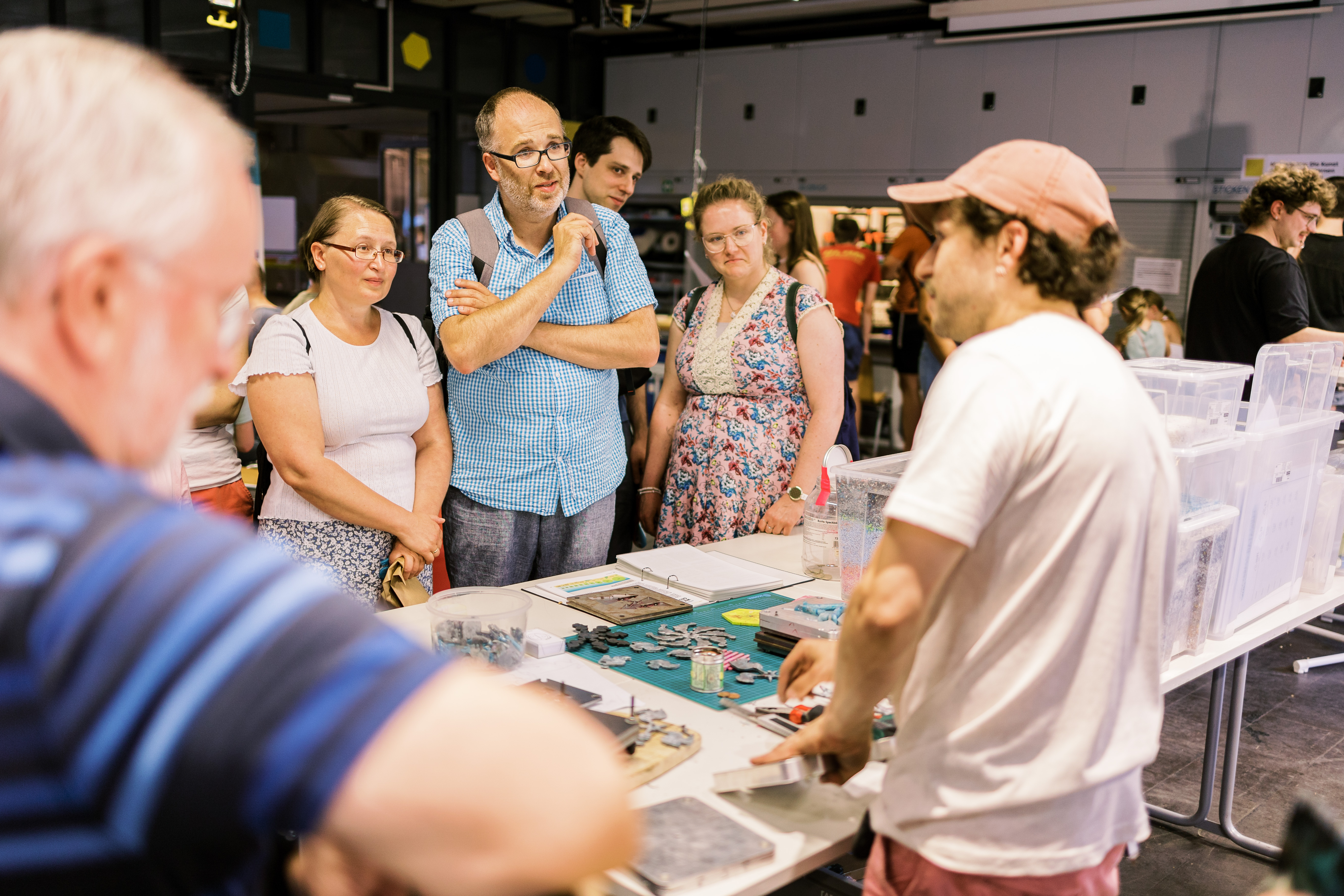 Besucher*innen hören den Erklärungen eines Mannes zu