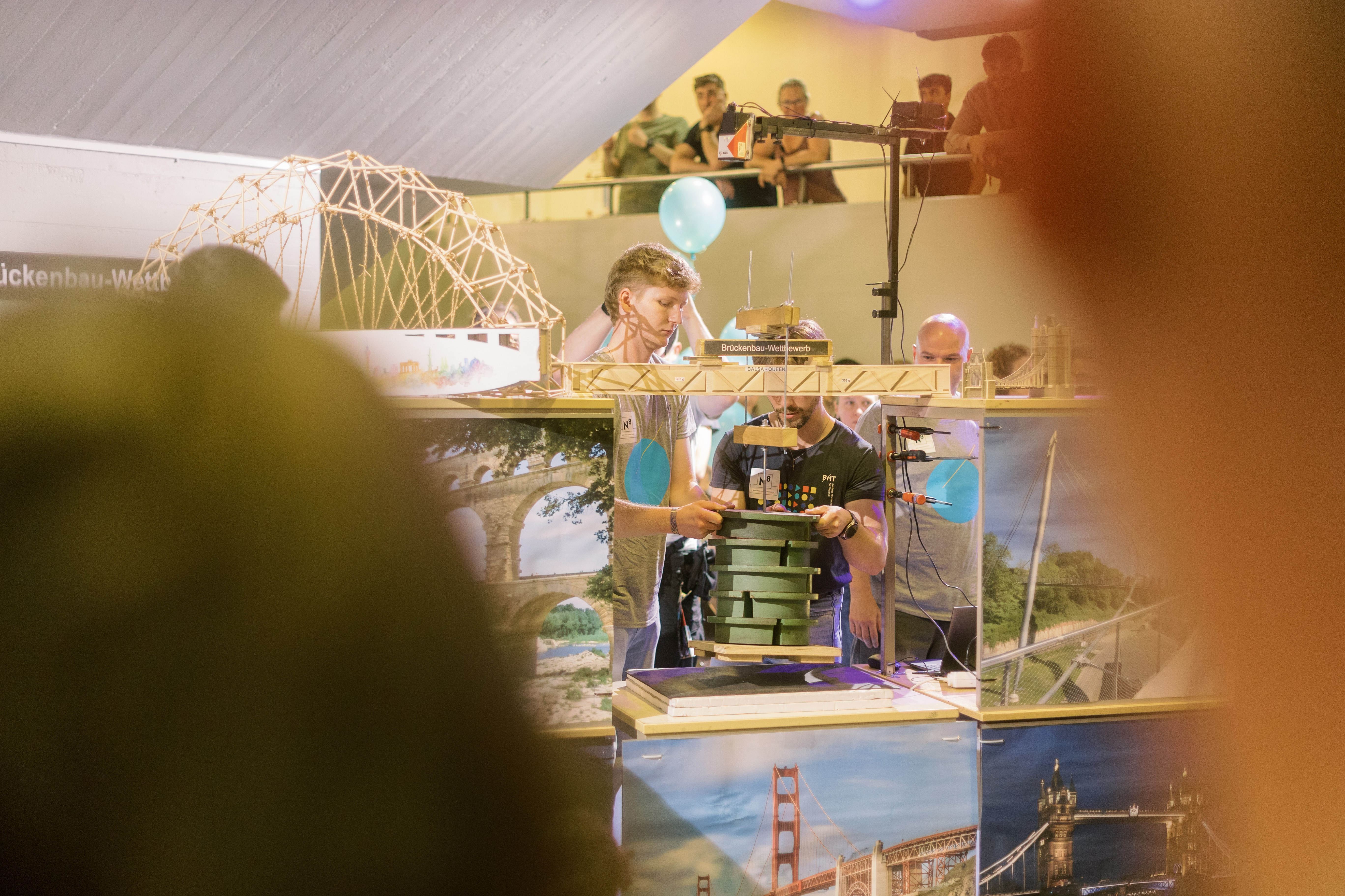 Zwei Männer bauen Brückenmodell an Testvorrichtung auf