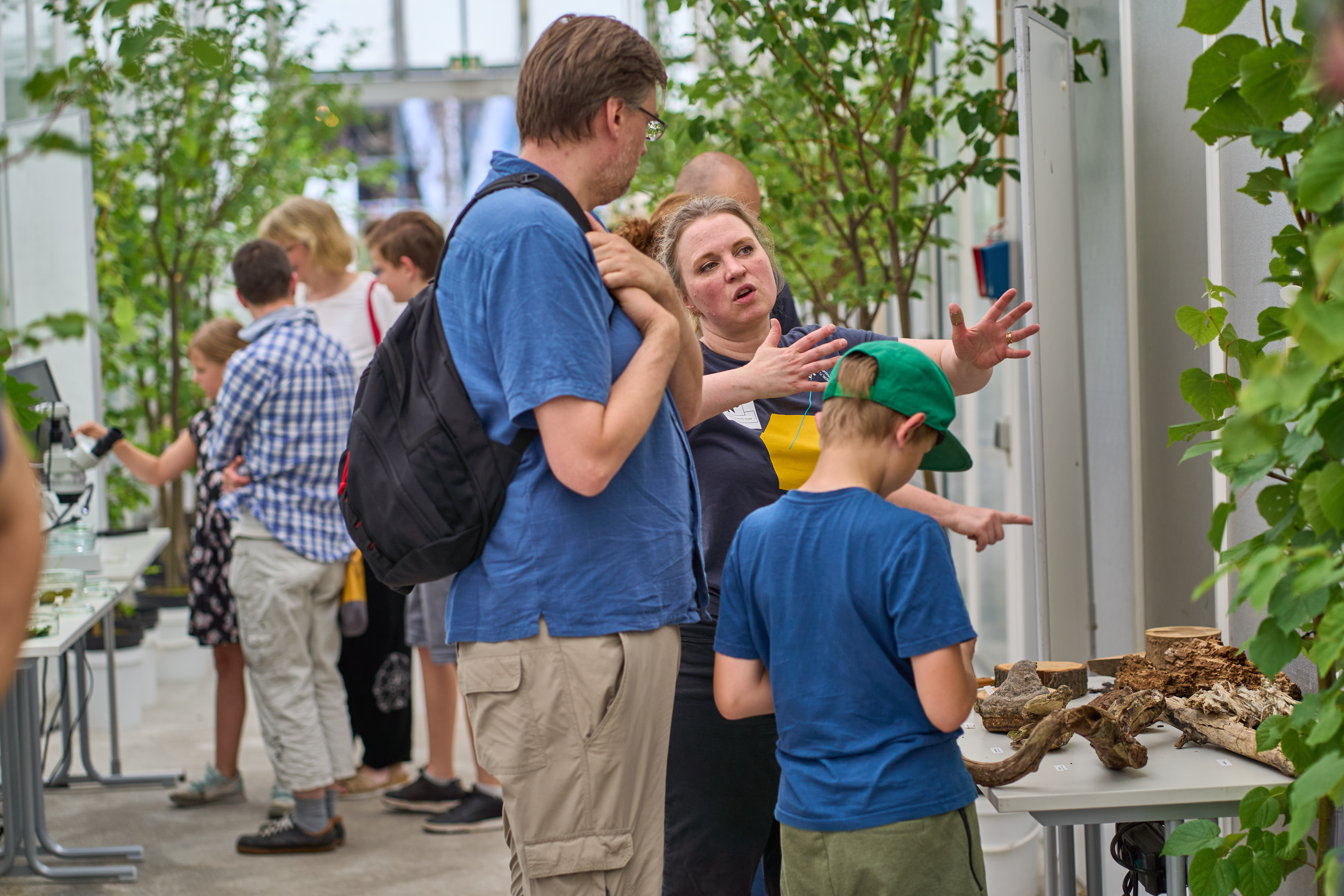 Mitarbeiter zeigt Besuchern etwas und beantwortet Fragen.