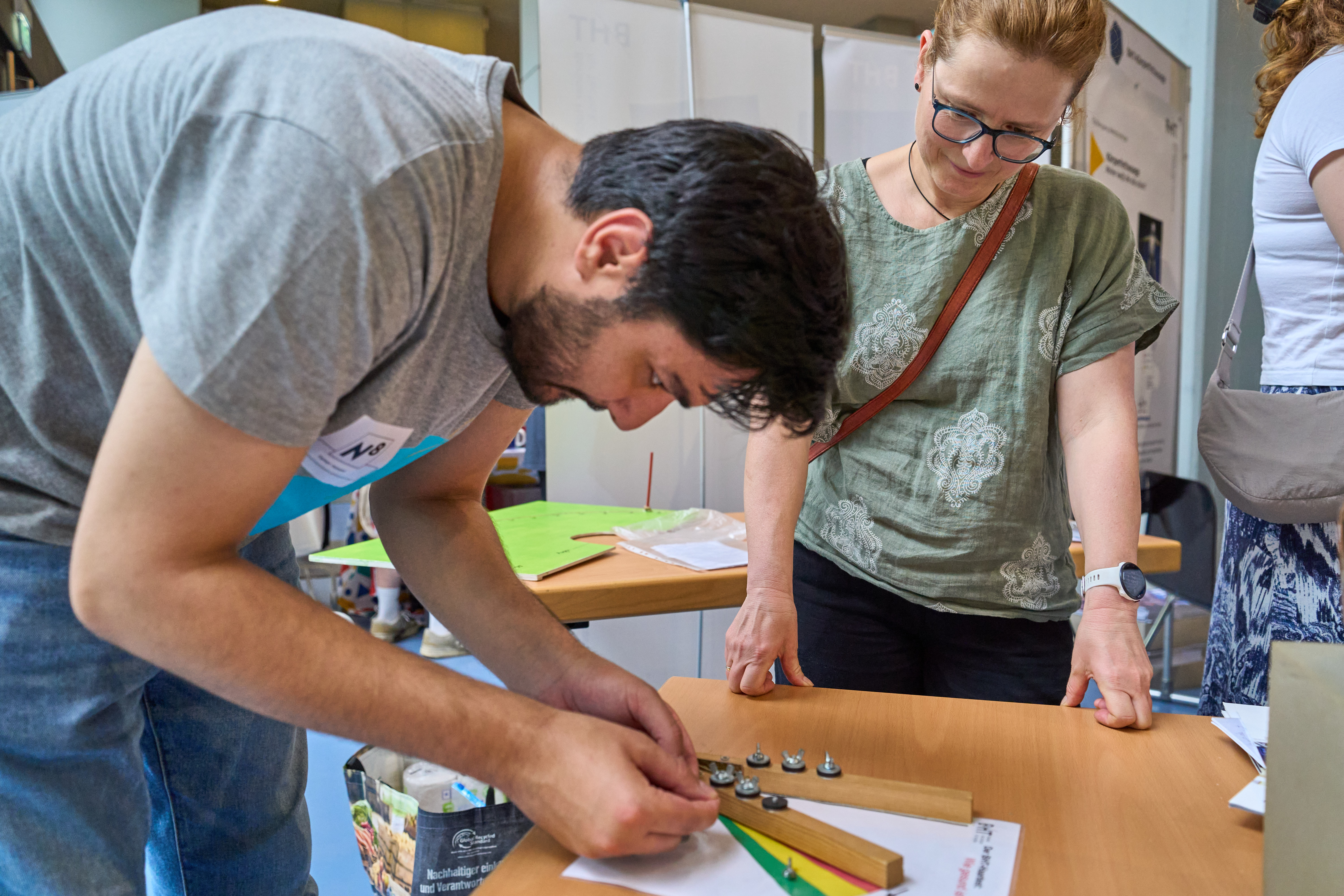Ein Mann baut etwas zusammen und eine Frau steht daneben.