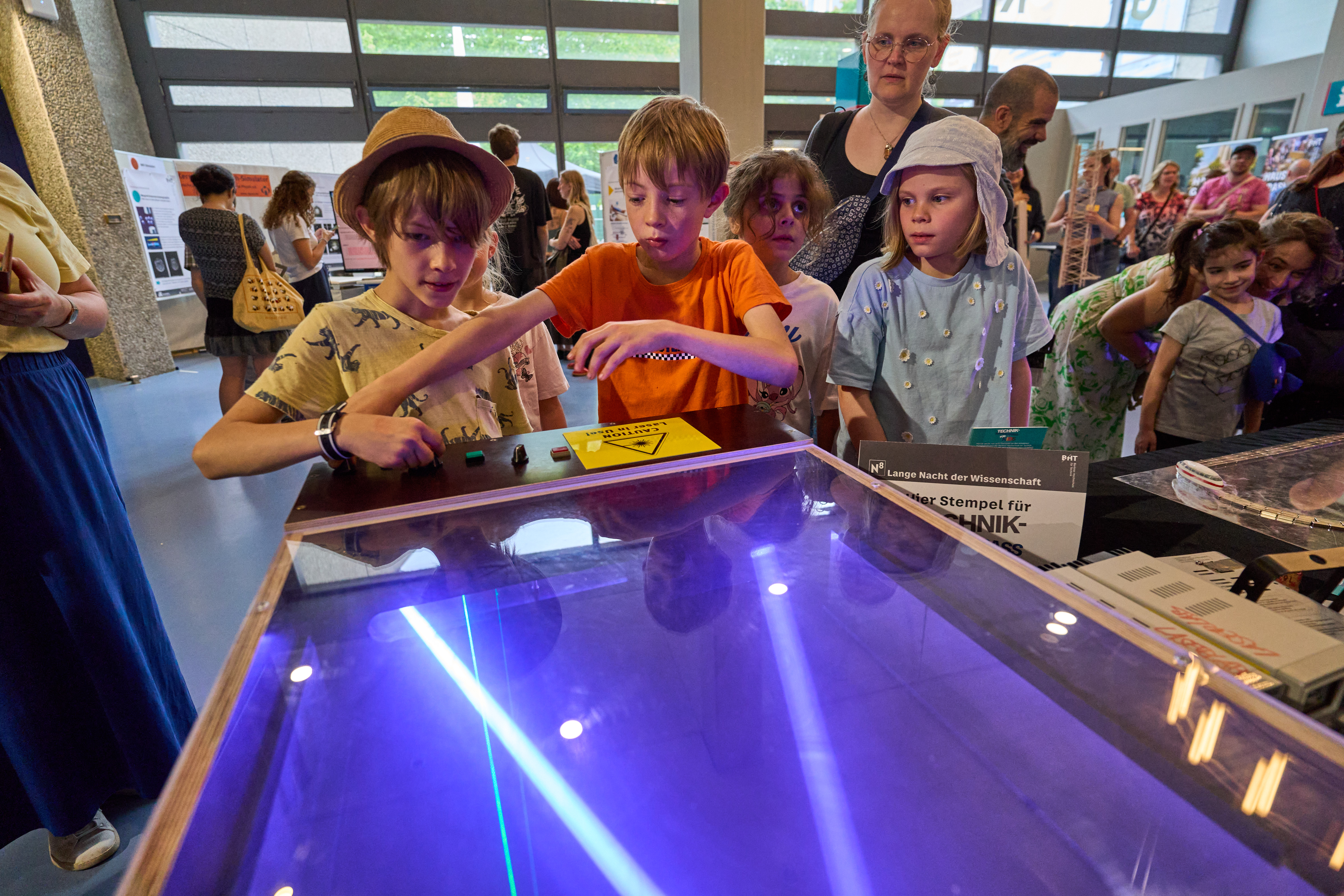 Zwei Jungs spielen an einem Gerät mit Lasern.