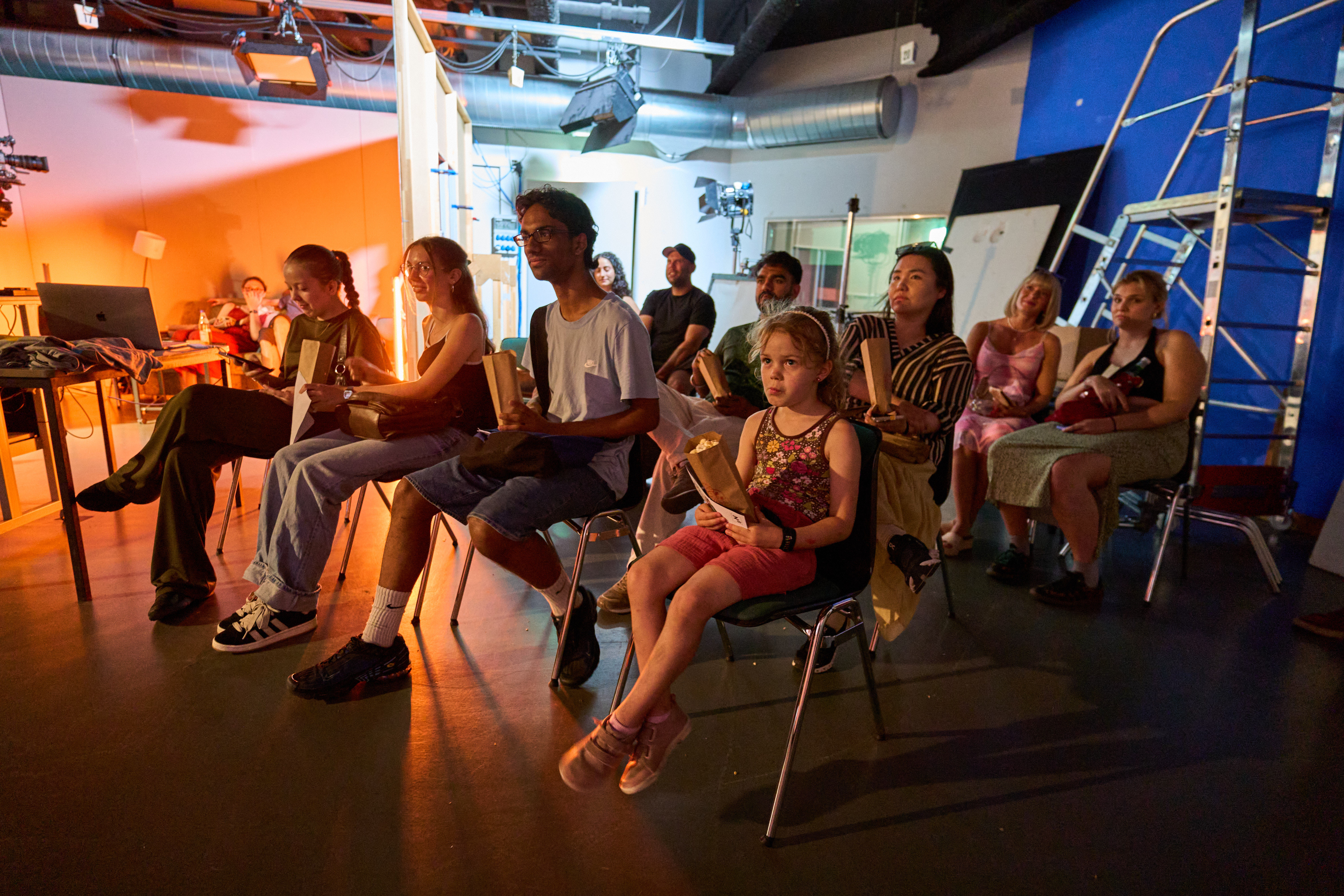 Menschen sitzen in Reihen und halten Popcorntüten.