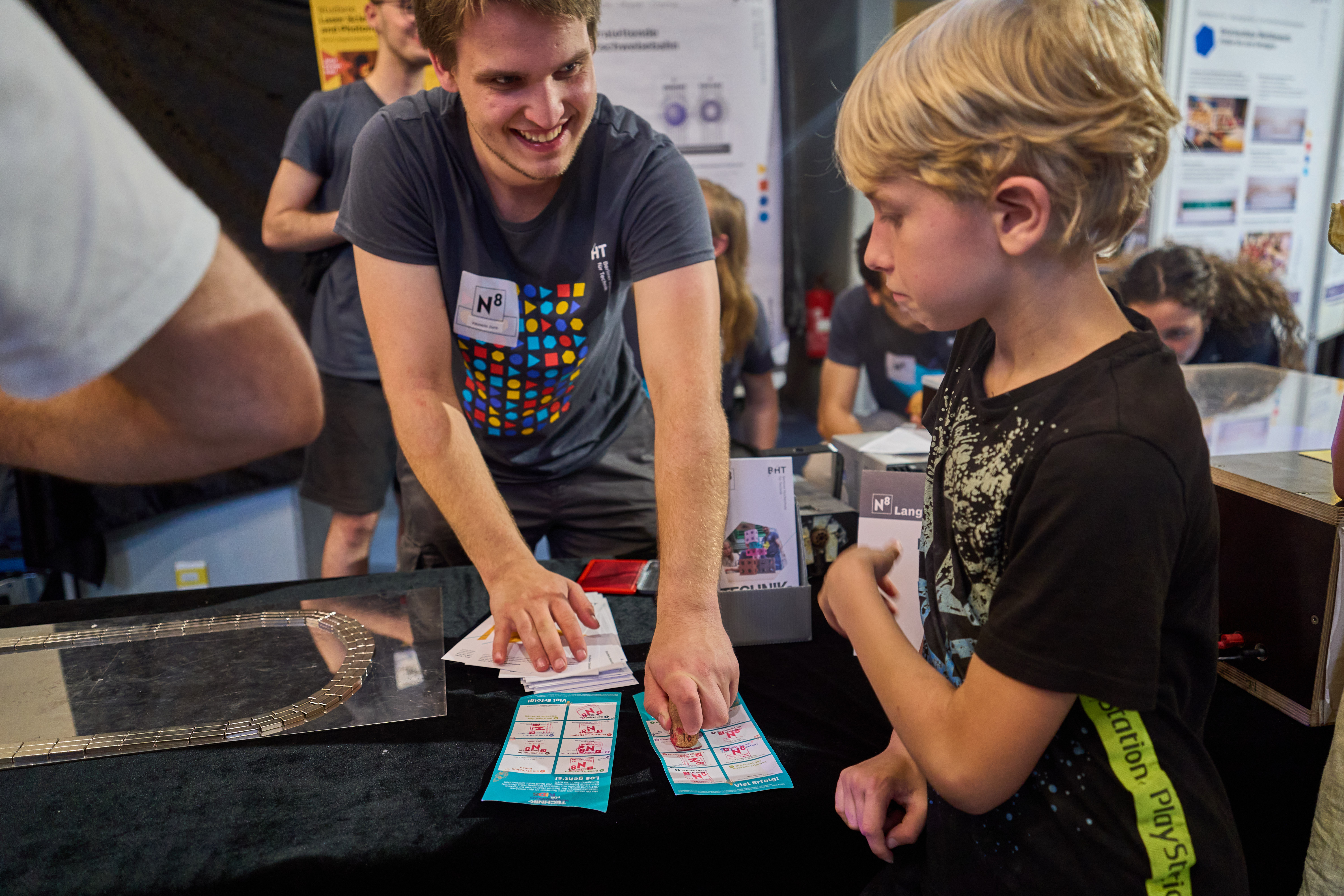 Kind bekommt Zettel von einem Mitarbeiter gestempelt.